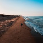 DAVID SIMPSON WALKING DOWN A QUIET BEACH IN PORTUGAL ALONE AT SUNRISE