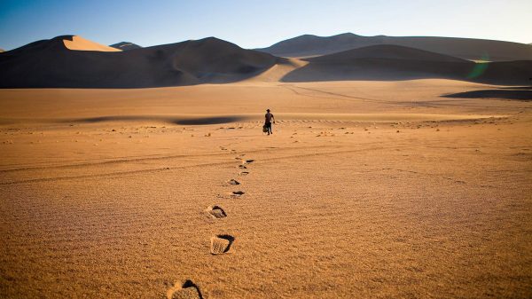 Man walking along in the desert on a sunny day. Scared of travelling alone?