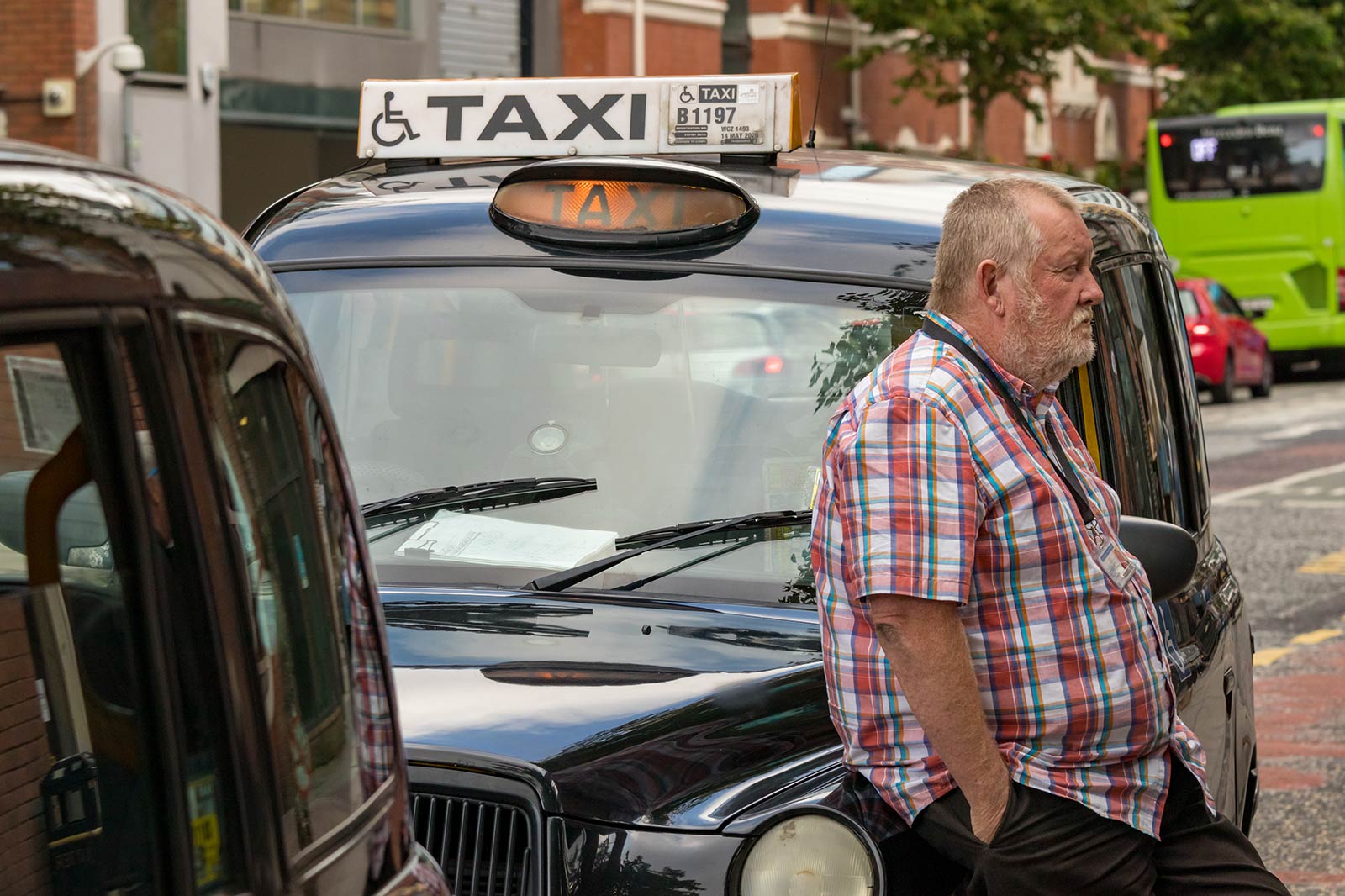Taxi driver leaning on his taxi in Belfast, Northern Ireland. 24hrs itinerary for Belfast, drinks and petrol bombs