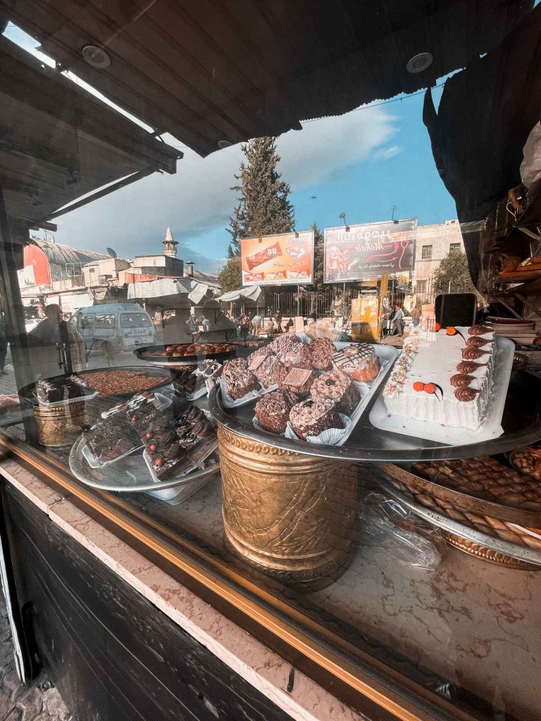 Cakes and treats on display at bakery shop in Palmyra, Syria. The ruined ruins of Palmyra
