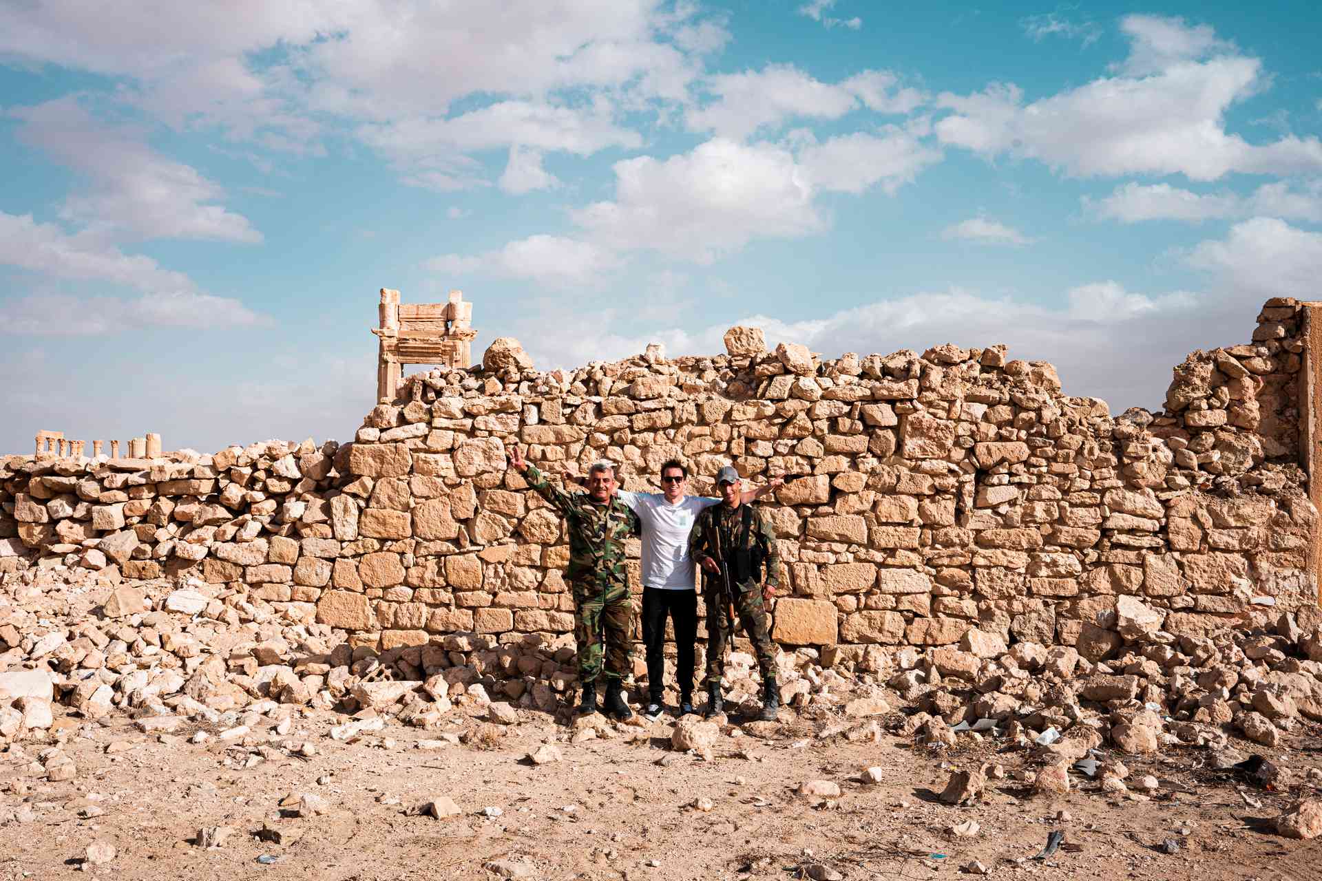 David Simpson and local soldiers standing at ruins in Palmyra, Syria. The ruined ruins of Palmyra