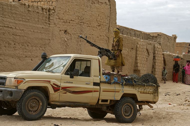 Man with machine gun on a truck in Palmyra, Syria. The ruined ruins of Palmyra