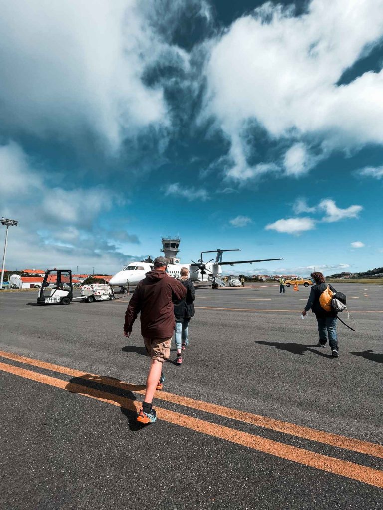 Passengers walking towards plane at tarmac of airport in Flores, The Azores. Walking on the Moon & prepping for climbing Pico