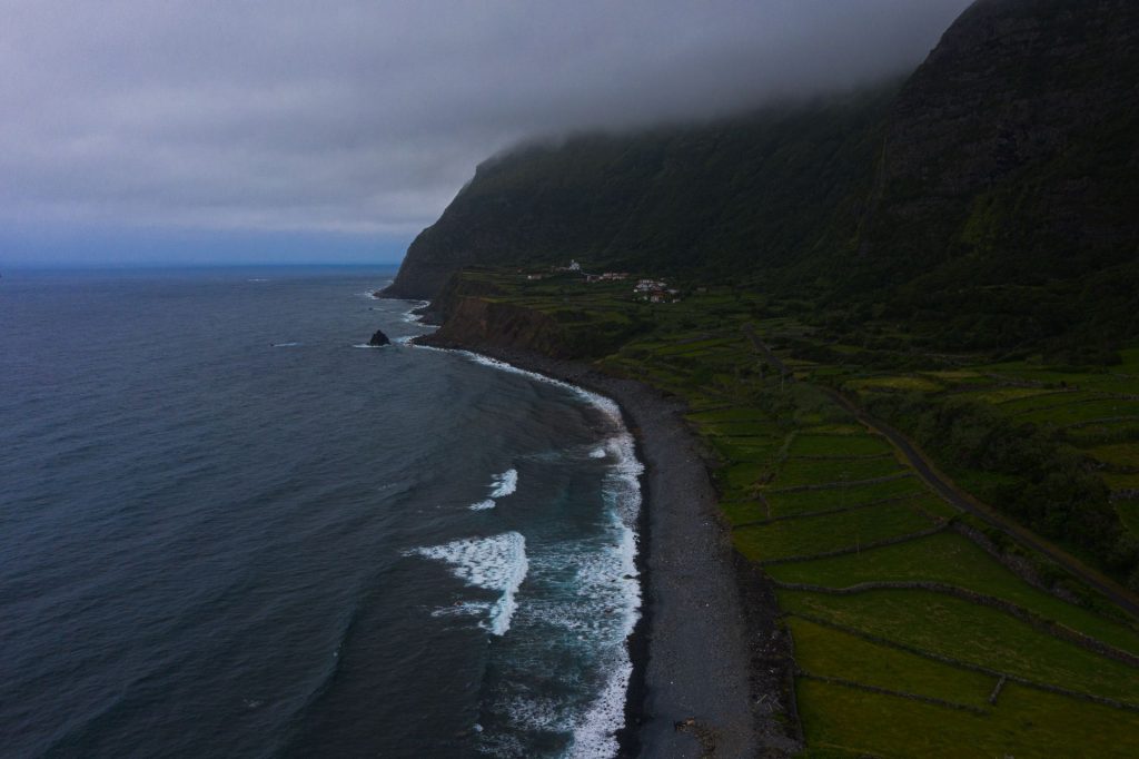 Aerial view of a beach near green fields in Flores, The Azores. 2 days looking at mist in Flores