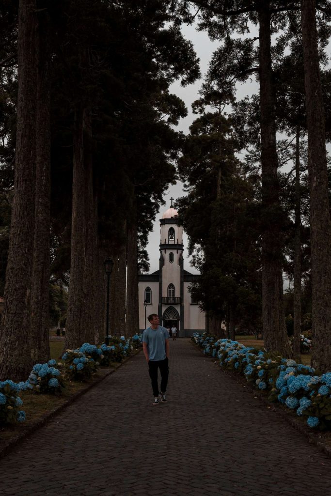 David Simpson walking away from the church under the trees in Miguel, The Azores. A day on San Miguel