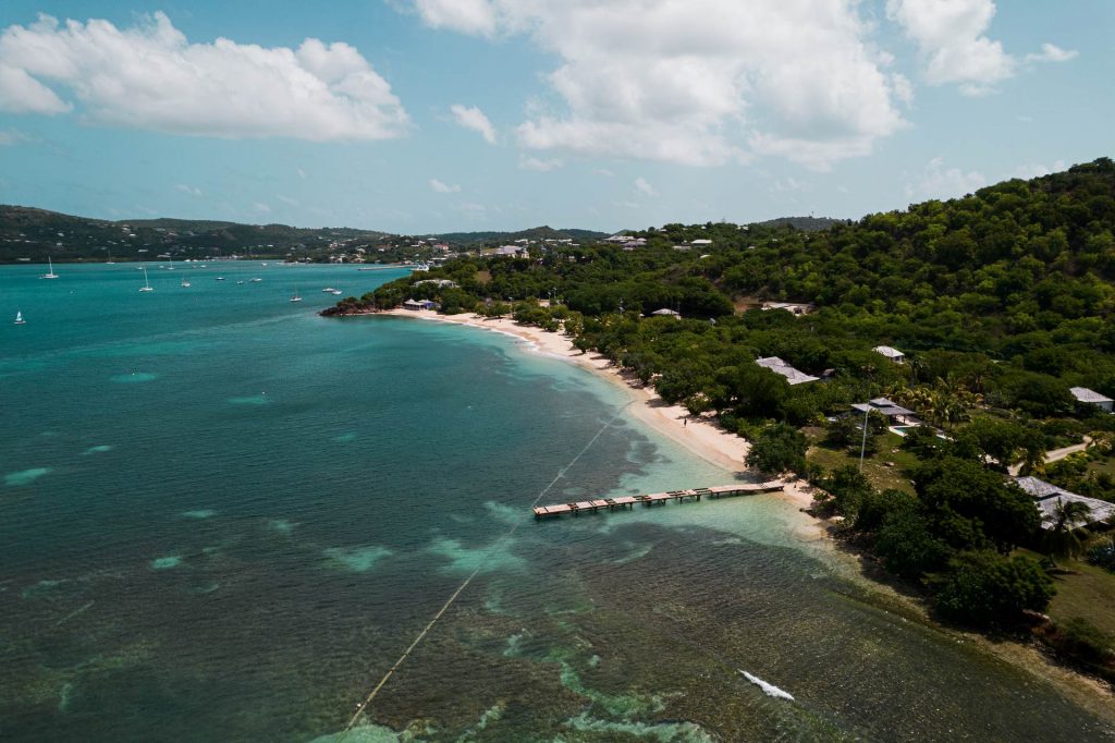 Aerial view of the sea, beach and island full of trees in Antigua. A day of beaches in Antigua