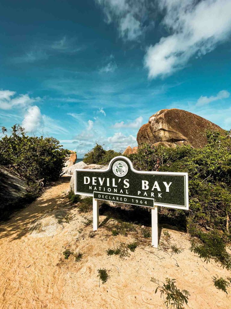 Devils Bay sign by the boulders and plants along the beach in British Virgin Islands. The baths at Virgin Gorda