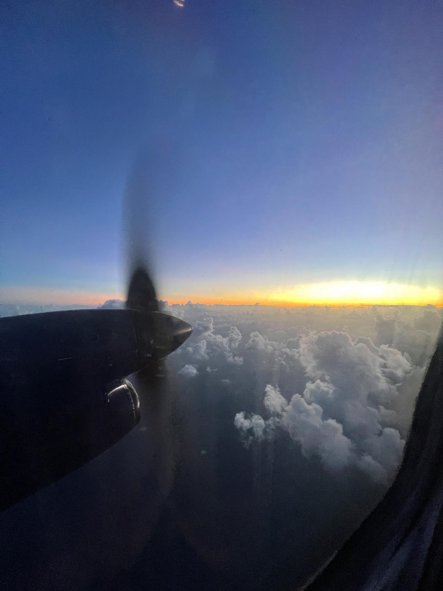 Plane window view of propeller, sunset and clouds in Antigua. Rendezvous beach and cliffside accom in BVI
