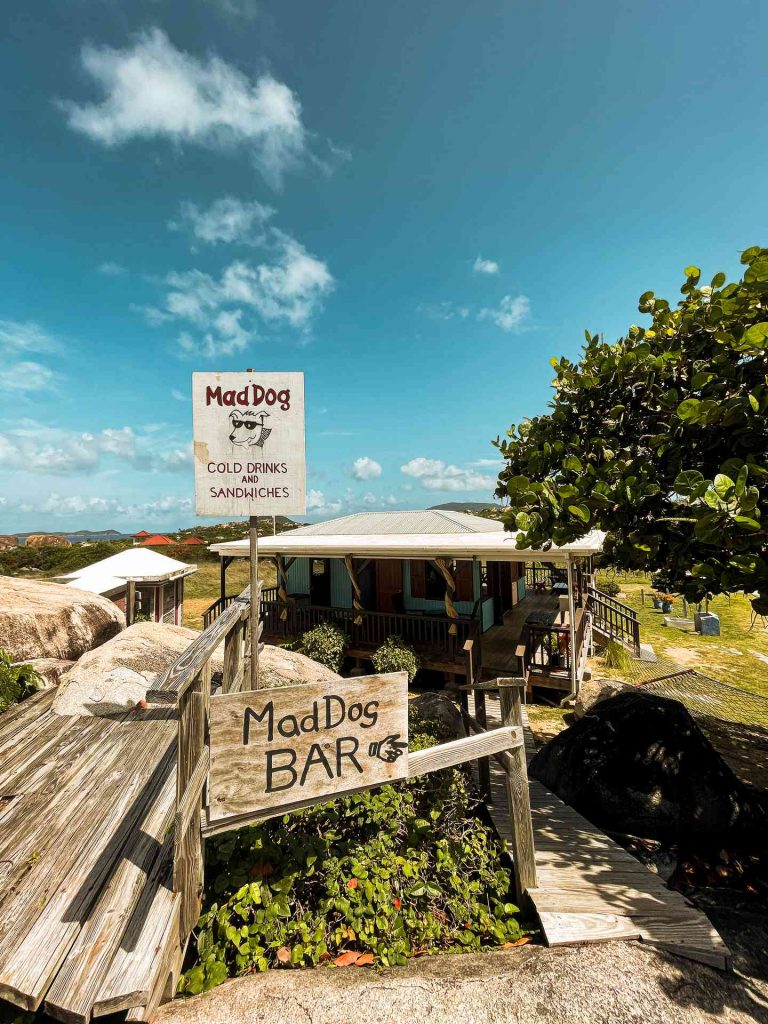 Mad Dog bar sign near a tree on a sunny day in British Virgin Islands. The baths at Virgin Gorda