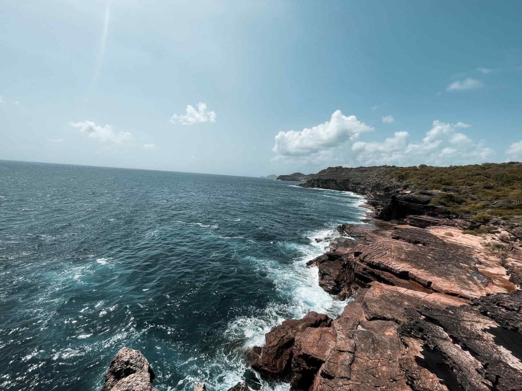 Rocky cliffs by the sea in Antigua. Sir Vivian Richards & don’t hike in flip flops