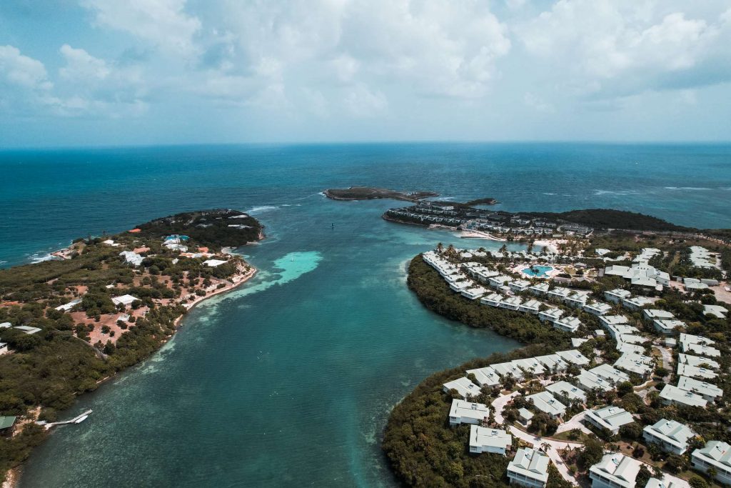 Aerial view of houses by the sea in Antigua. Sir Vivian Richards & don’t hike in flip flops