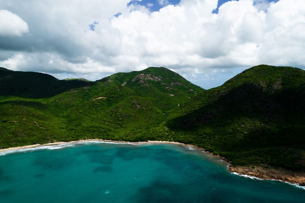 Aerial view of sea, beach and mountain in Antigua. Rendezvous beach and cliffside accom in BVI