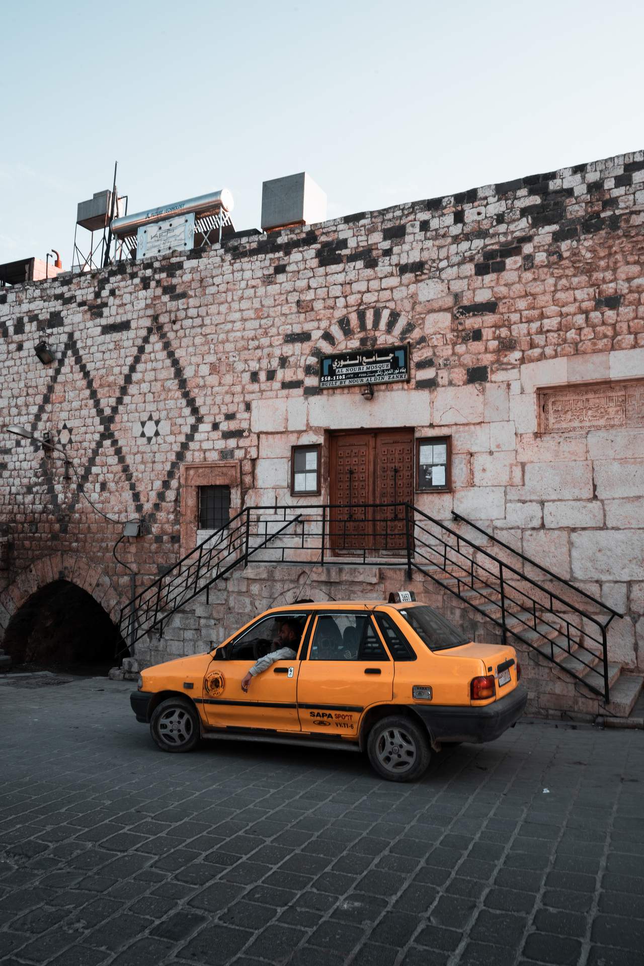 Taxi parked infront of a mosque in Aleppo, Syria. Staying safe when travelling
