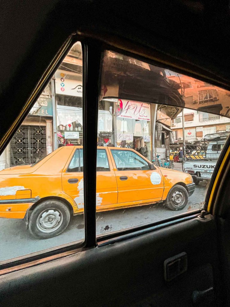Car parked by the side of the street and shops in Damascus, Syria. A day in Damascus