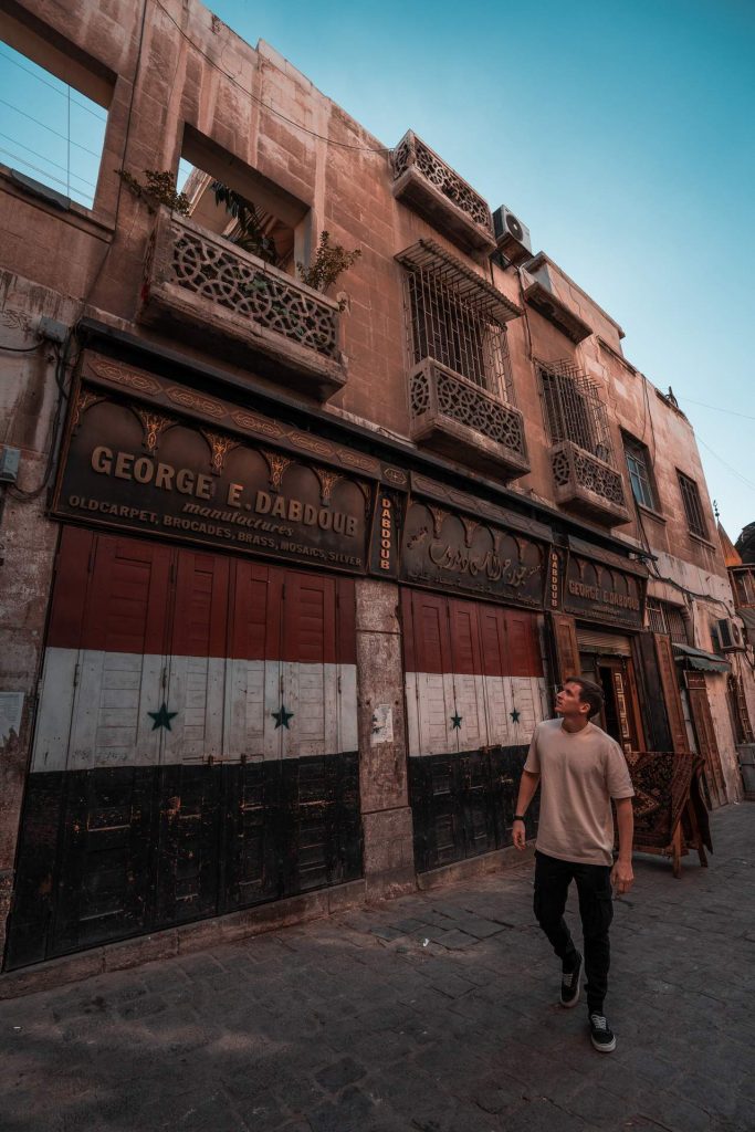 David Simpson walking past closed shops in Damascus. The Syrian Series reflection post