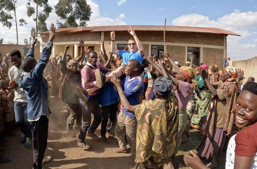 David Simpson being carried on shoulders by Batwa people in Burundi. The East African Series photo album