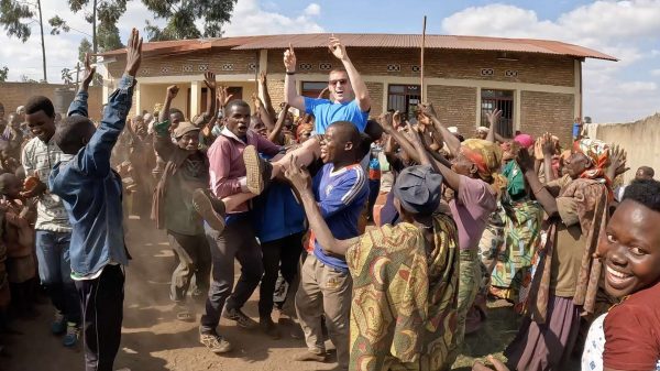 David Simpson being carried on shoulders by Batwa people in Burundi. The East African Series photo album