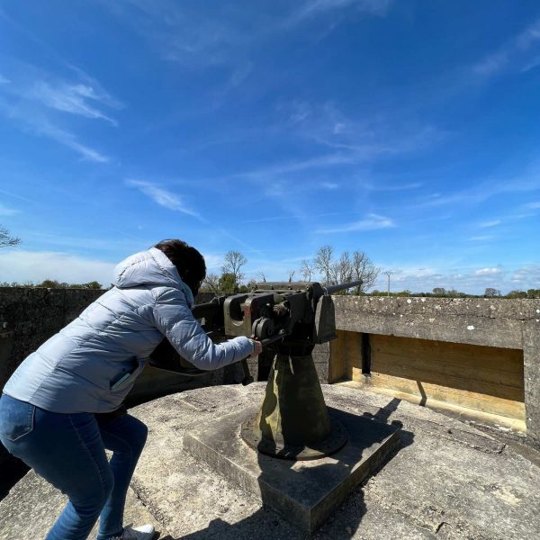 Mom aiming machine gun in Crisbecq Battery in Normandy, France. The best steak & omelette in the world in the same day