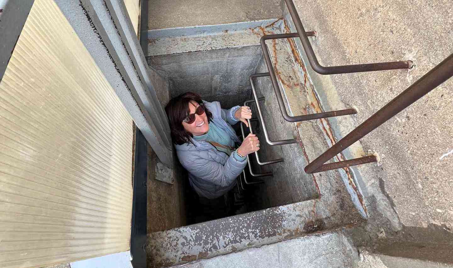 Mom climbing down ladder in The Grand Bunker in Normandy, France. Is there any such thing as a good beach in Normandy?