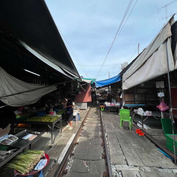 Stalls and railroad tracks at Maeklong train market in Thailand. Maeklong train market in Thailand. Shotguns, markets and temples in Bangkok