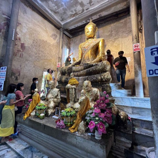 Giant buddha and worshippers at Wat Bang Kung in Thailand. Shotguns, markets and temples in Bangkok