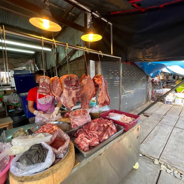 Butcher at Maeklong train market in Thailand. Shotguns, markets and temples in Bangkok