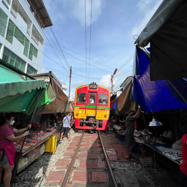 Train passing at Maeklong train market in Thailand. Shotguns, markets and temples in Bangkok