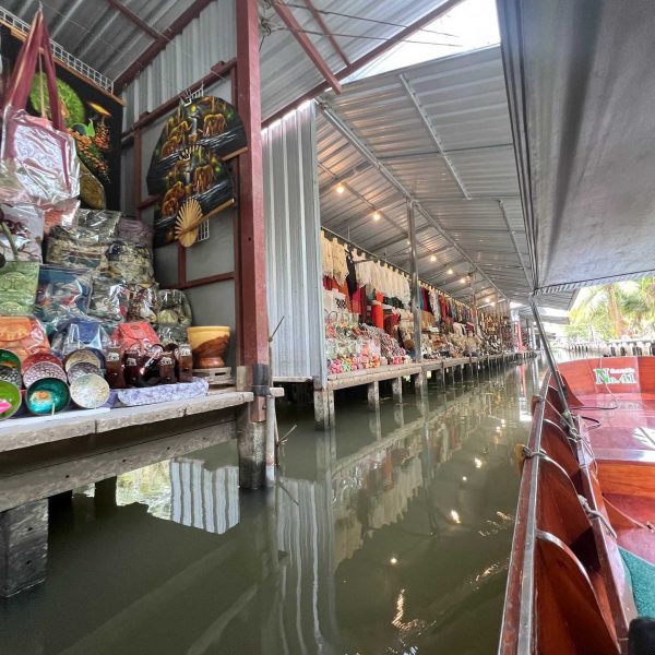 Stalls along the river at Damnoen Saduak Floating Market in Thailand. Shotguns, markets and temples in Bangkok