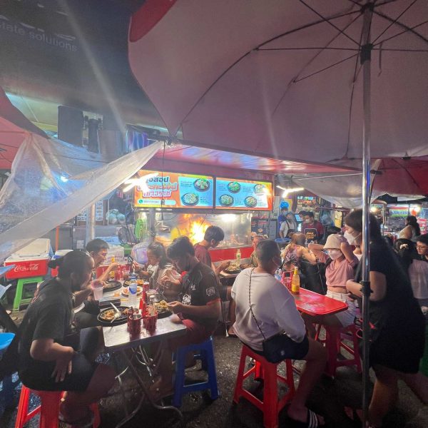 People eating on the sidewalk at night at Chinatown in Bangkok, Thailand. The day to end all days in Bangkok