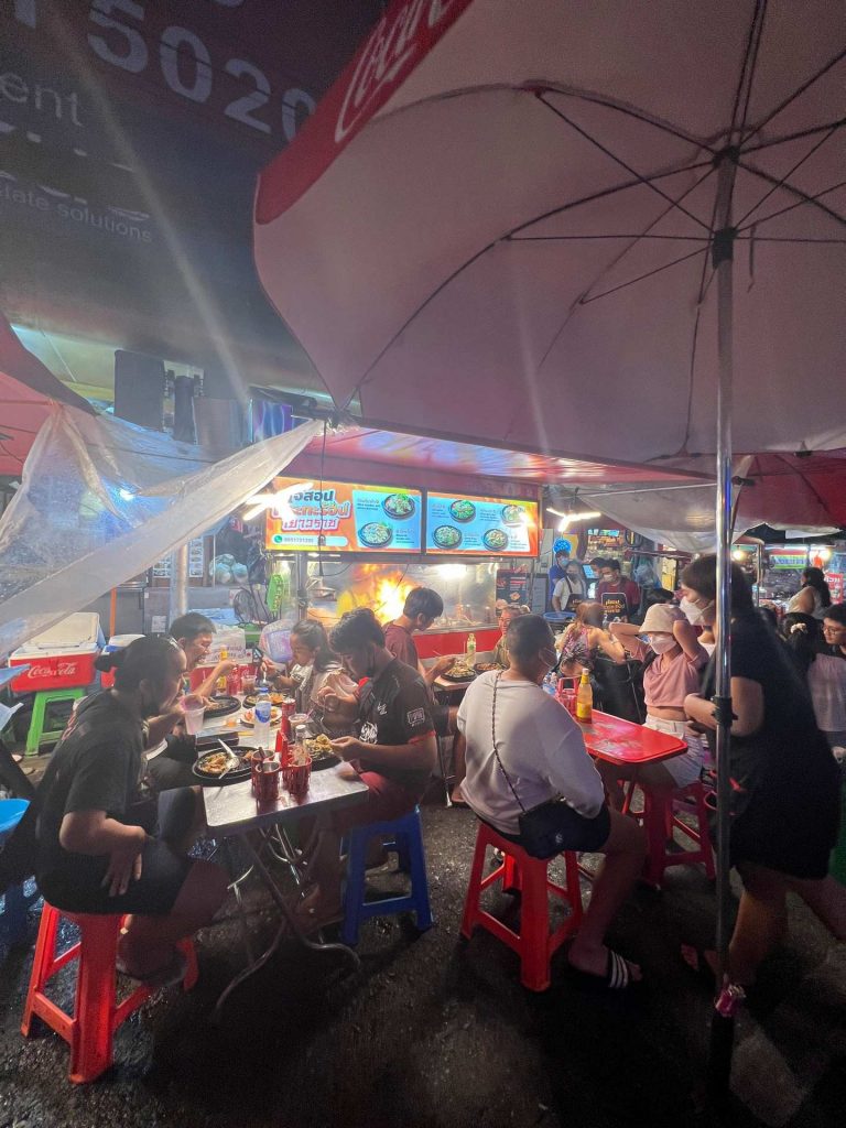 People eating on the sidewalk at night at Chinatown in Bangkok, Thailand. The day to end all days in Bangkok