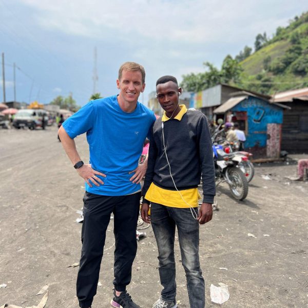 David Simpson and local guy standing at the side of the road in Tchegera Island, DRC. Checkpoint trouble and Tchegera Island all alone