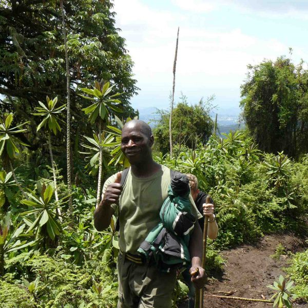 Ranger hiking Mt. Bisoke summit in Rwanda. Climbing Mt Bisoke