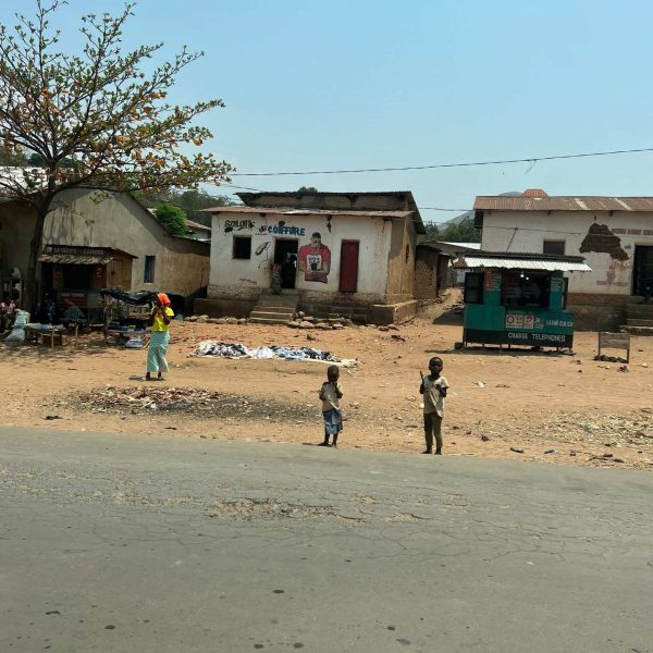 Houses and local children by the side of the road in DRC. Caught filming at the DRC border