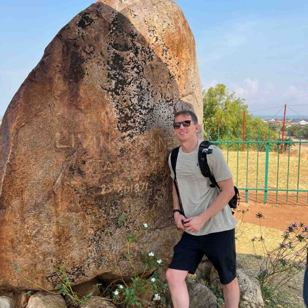 David Simpson standing beside boulder in Bujumbura, Burundi. Checking out Bujumbura