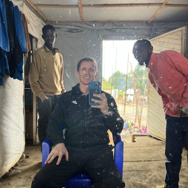 David Simpson and local guys in front of mirror in Tchegera Island, DRC. Checkpoint trouble and Tchegera Island all alone