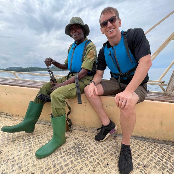 David Simpson and ranger onboard a boat in Musanze, Rwanda. Climbing Mt Bisoke