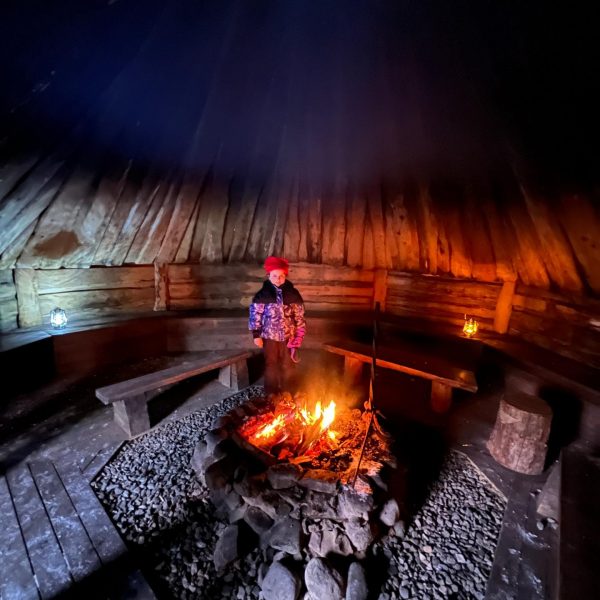 Niece by the campfire inside the cabin in Rovaniemi, Finland. Christmas Day in Lapland