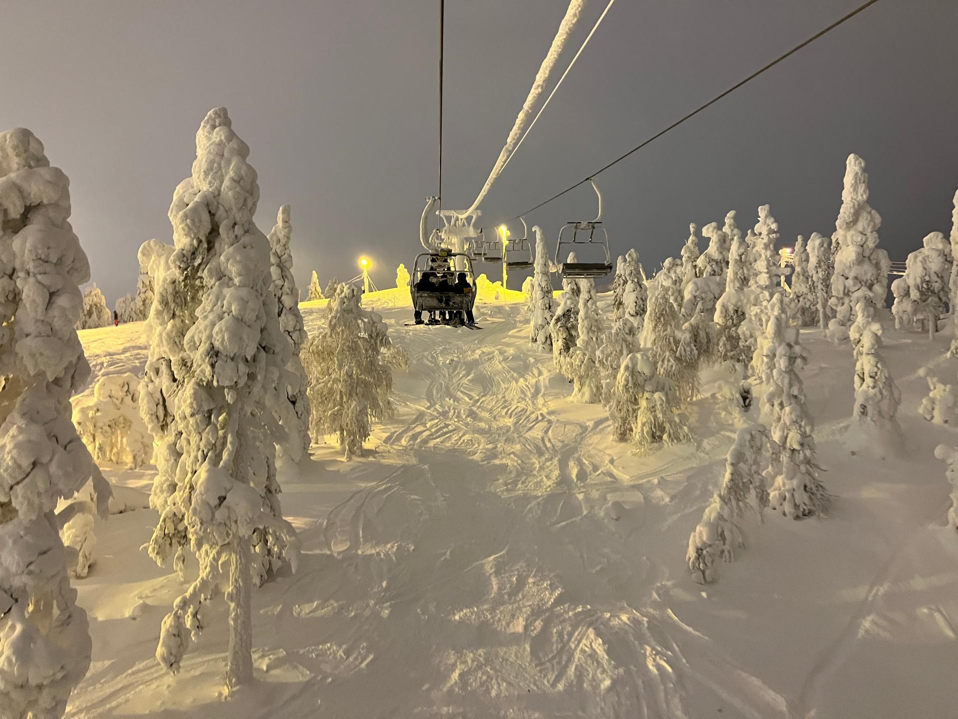 Riding the ski lift over snow covered trees in Ruka, Finland. The Lapland Series reflection post