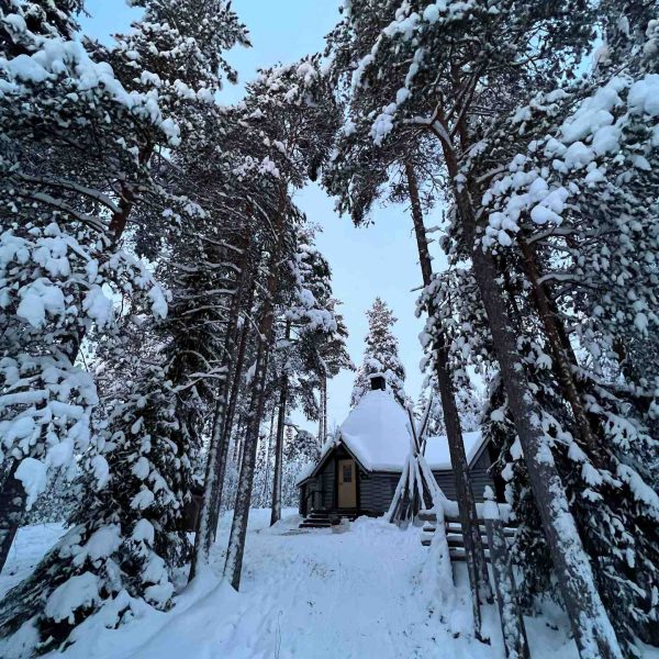 Cabin in the snow covered woods in Rovaniemi, Finland. Christmas Day in Lapland