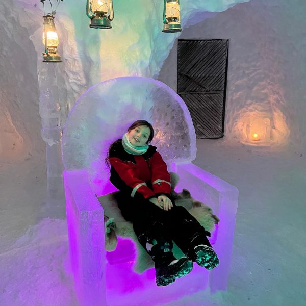 Niece sitting on ice throne in Rovaniemi, Finland. Christmas Day in Lapland