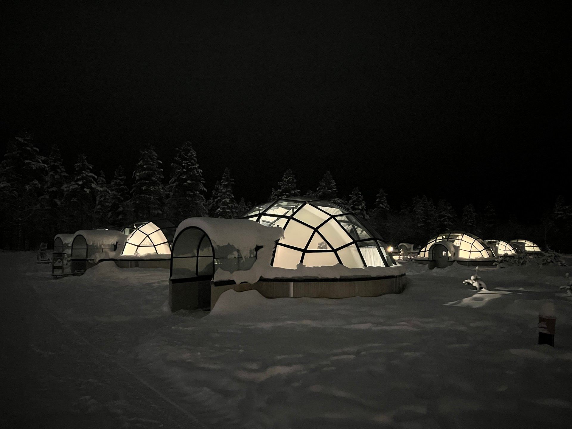 Glass igloo at night in Saariselka, Finland. Frozen karting & husky rides