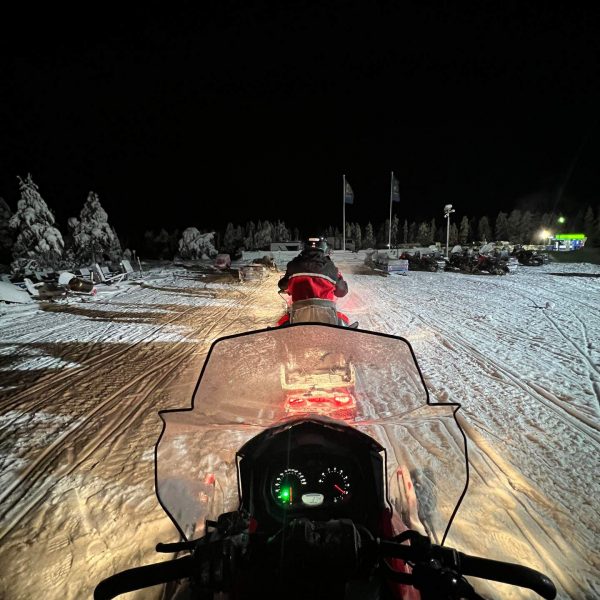 Riding the snow mobiles at night in Rovaniemi, Finland. Christmas Day in Lapland
