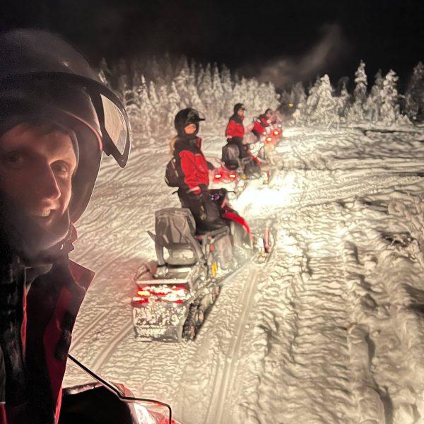 David Simpson and family riding snow mobiles at night in Rovaniemi, Finland. Christmas Day in Lapland