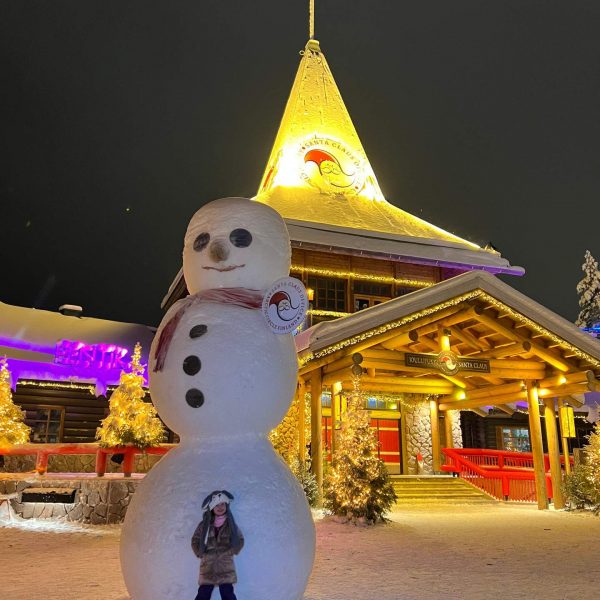 Niece and giant snowman in Rovaniemi, Finland. Christmas Day in Lapland