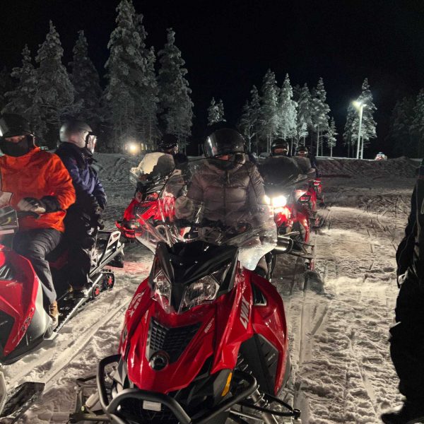 People on snow mobiles at night in Ivalo, Finland. The truth about Kakslauttanen Arctic resort