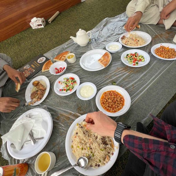 Eating food in Kabul, Afghanistan. Crazy friday flag with Afghan locals