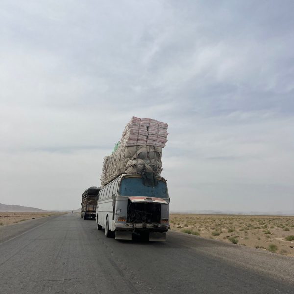 Bus loaded with cargo passing thru the ring road in Herat, Afghanistan. Flour mill, super noodles and the Afghan Ring road