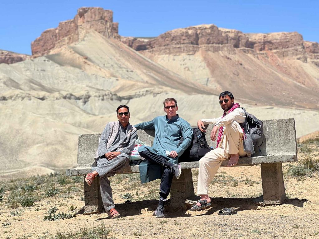 David Simpson with local guys seated under the sun in Bamiyan, Afghanistan. Bamiyan, Qlukhi & The Buddhas
