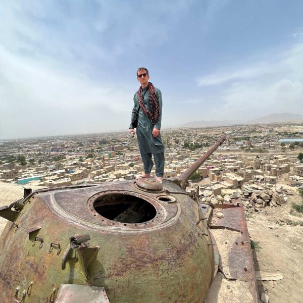 David Simpson standing on war relic overlooking residential houses in Ghazi, Afghanistan. Sandstorm, bricks & cramps; Kabul to Kandahar