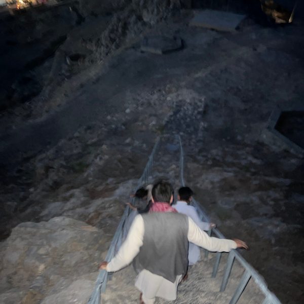 Local people climbing down ladder at night in Kandahar, Afghanistan. Sandstorm, bricks & cramps; Kabul to Kandahar